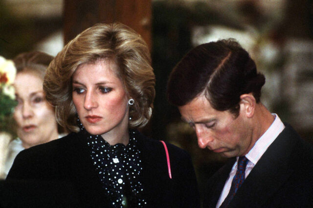 Prince Charles looking down as Princess Diana looks to the side beside him.