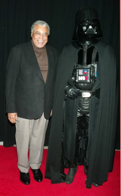 James Earl Jones standing beside a Darth Vader.