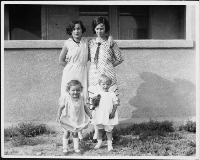 Gladys Pearl Baker and Norma Jeane Mortensen standing with a woman and child