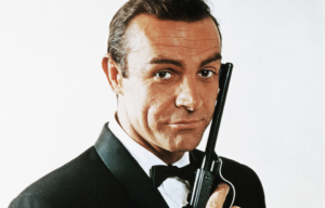 Sean Connery as James Bond, holding a gun against his face.