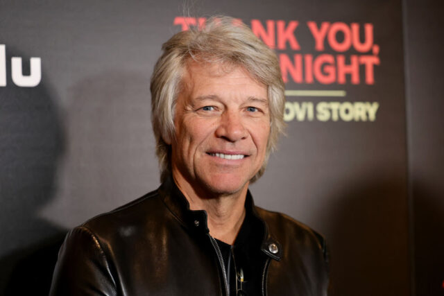 Jon Bon Jovi standing on a red carpet