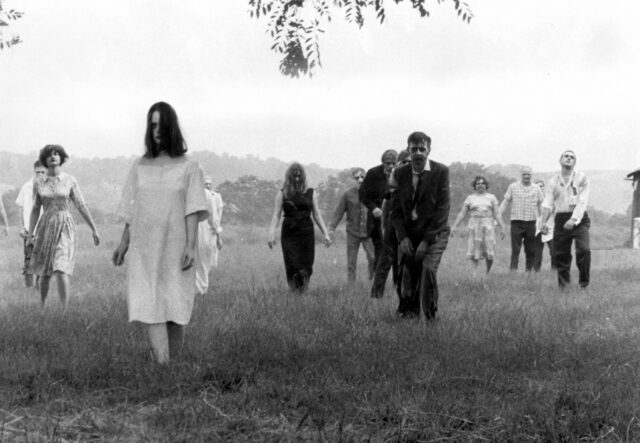 People walking like zombies in a field.