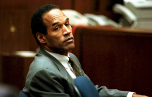 O.J. Simpson leaning in a chair in a courtroom.