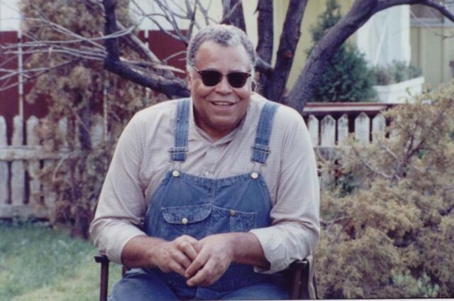 James Earl Jones wearing sunglasses and sitting in a chair.