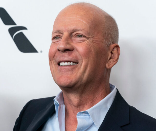 Bruce Willis standing on a red carpet