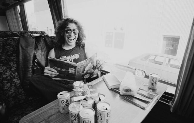 Alex Van Halen reading a magazine on a tour bus