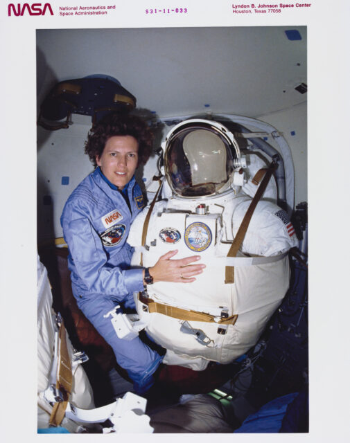 Kathryn Sullivan holding a space suit.