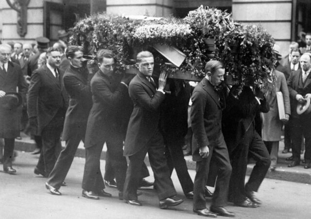 Several men pall-bearing Houdini's casket.