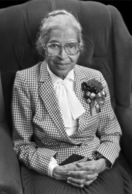 Rosa Parks in her older age sitting in a chair.