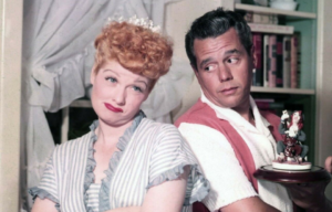 Headshot of Lucille Ball and Desi Arnaz standing back-to-back.