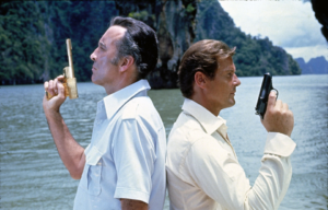 Roger Moore standing back-to-back with Christopher Lee, both holding up guns in 'The Man With the Golden Gun.'