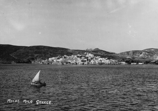 Sailboat moving past the coast of Milos, Greece