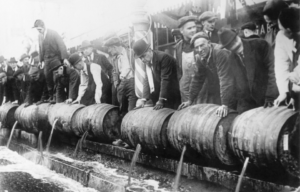 Men lined up, dumping barrels of beer into the sewer.