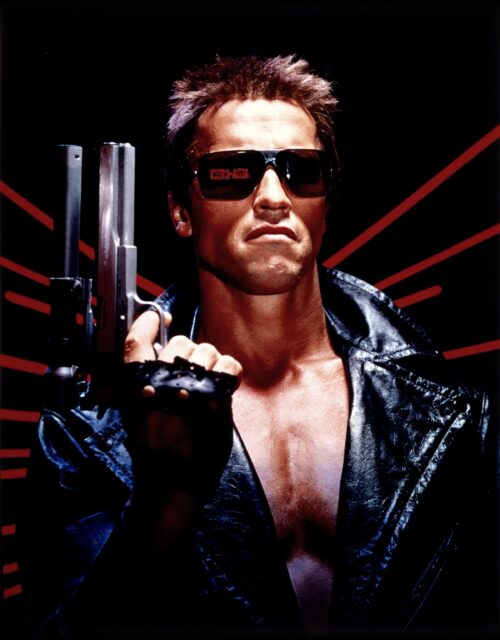 Arnold Schwarzenegger in sunglasses and holding up a gun as 'The Terminator.'