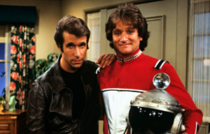 Henry Winkler and Robin Williams standing on the set of 'Happy Days'