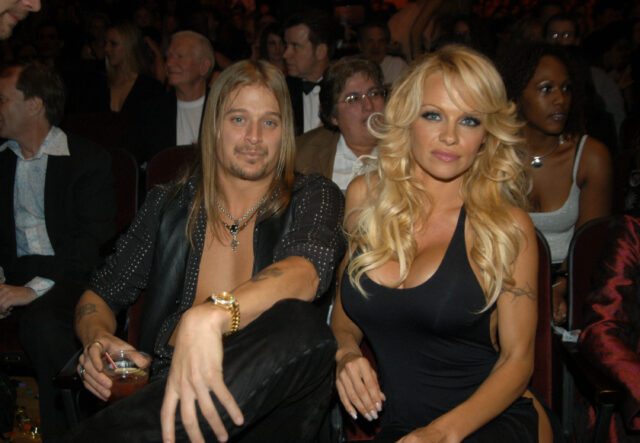 Kid Rock and Pamela Anderson sitting beside each other.