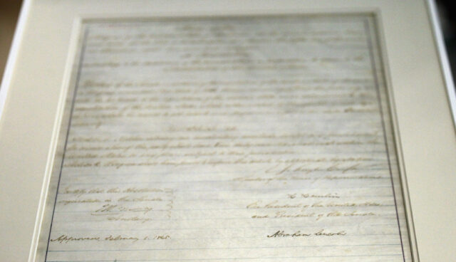 Photograph of the 13th amendment, signed by Abraham Lincoln, in a frame.