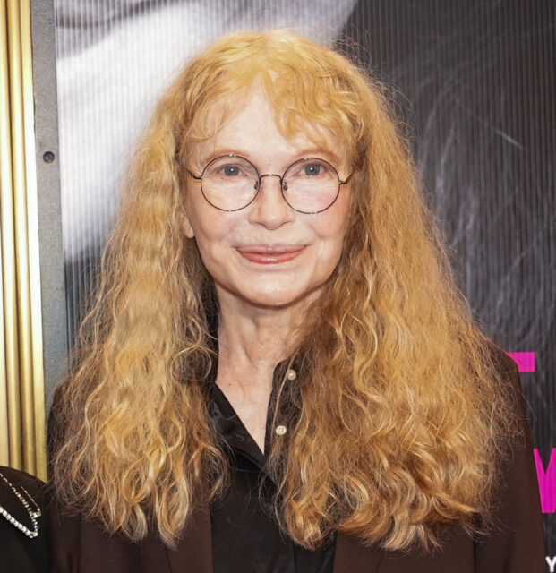 Mia Farrow standing on a red carpet