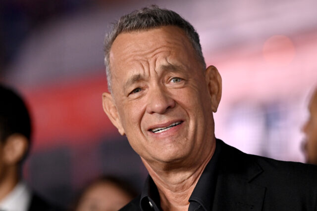 Tom Hanks standing on a red carpet