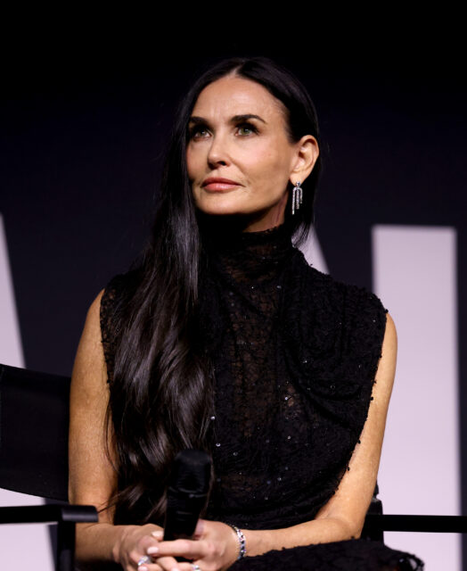 Demi Moore sitting on stage