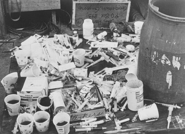 A table covered in cups and syringes.