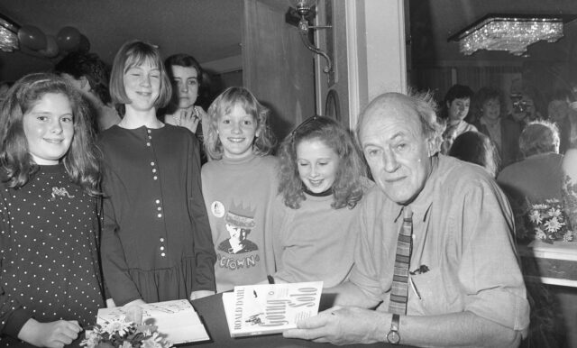 Roald Dahl signs autographs for a group of children. 