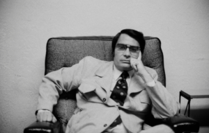 Jim Jones leaning on his hand in a chair.