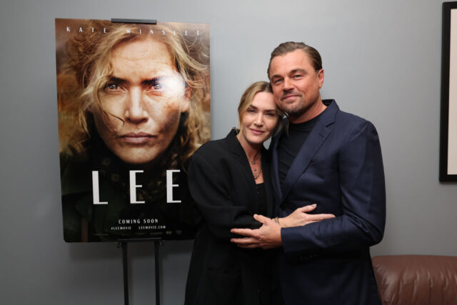 Kate Winslet and Leonardo DiCaprio standing next to a poster for the film 'Lee'