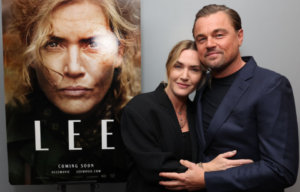 Kate Winslet and Leonardo DiCaprio standing next to a poster for the film 'Lee'