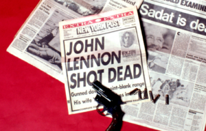 Closeup of newspaper headlining John Lennon's death.