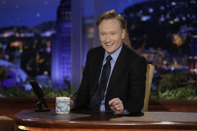 Conan O'Brien sitting on the set of 'The Tonight Show with Conan O'Brien'