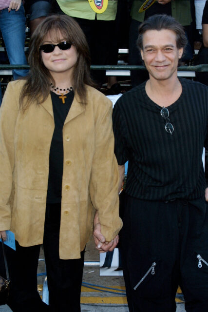 Valerie Bertinelli and Eddie Van Halen holding hands and smiling for a photo together.