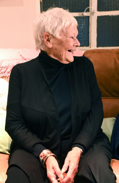 Judi Dench looking to the side while laughing