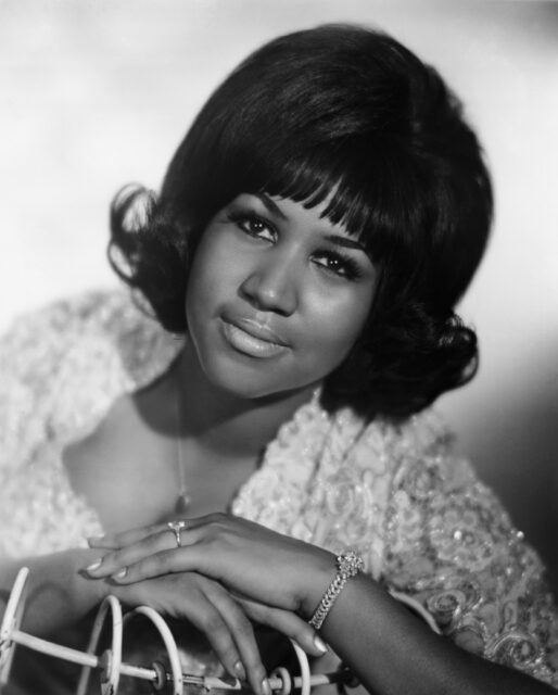 Headshot of Aretha Franklin sitting and leaning on something.