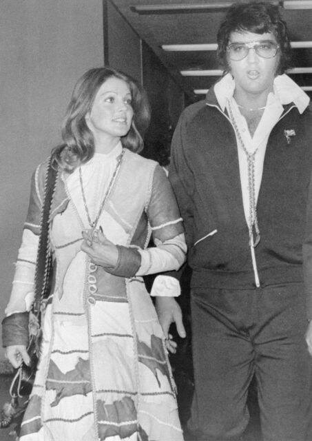 Elvis and Priscilla Presley walking together.